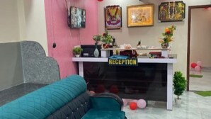 Ein Empfangsbereich mit einem türkisfarbenen Sofa, einem Empfangstresen und einem Schild mit der Aufschrift 'RECEPTION'.