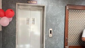 Ein Empfangsbereich mit einem Schild, das die erste Etage anzeigt, und einer Rezeption.