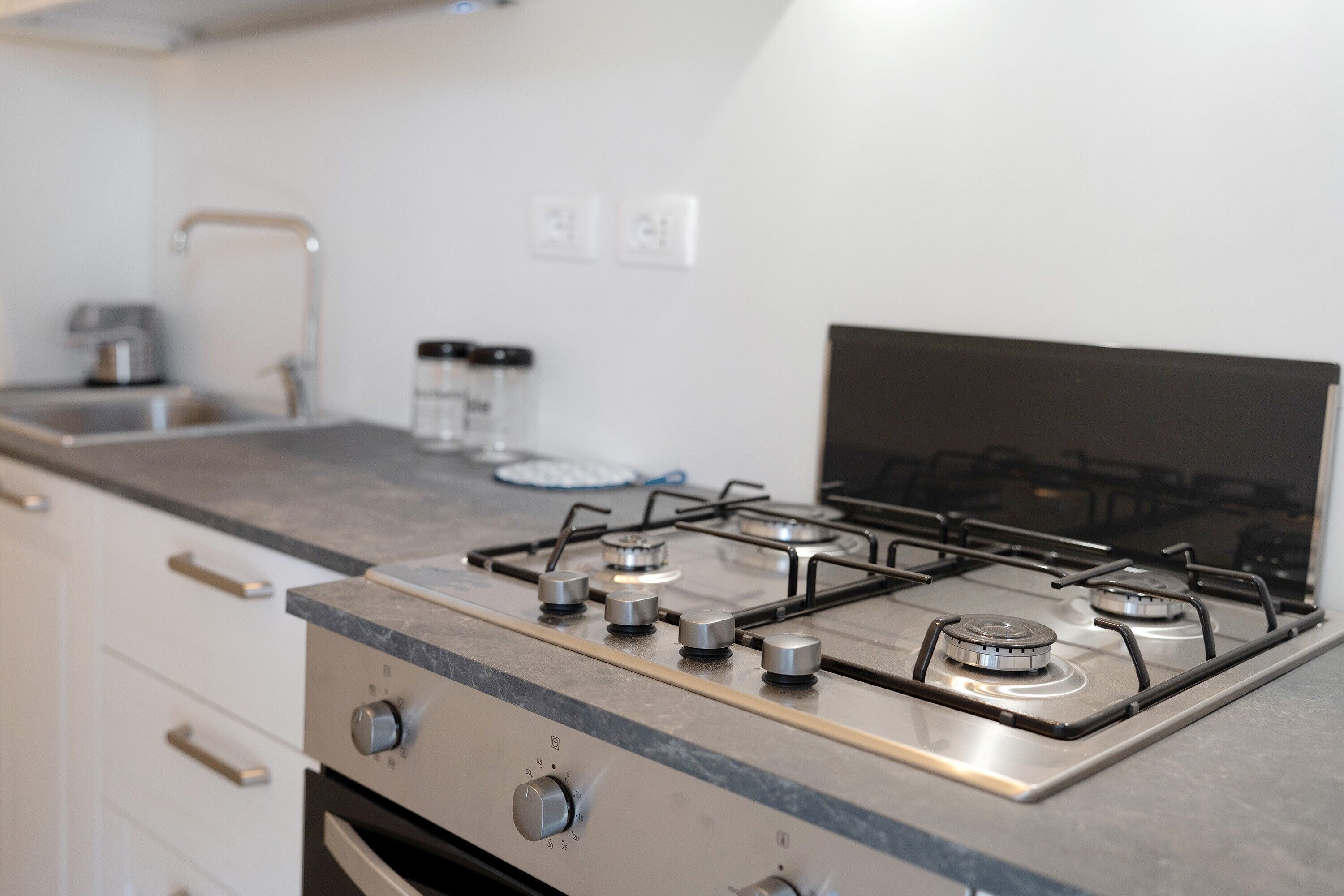 Una cucina con piano cottura a gas, elettrodomestici in acciaio inossidabile e un design moderno.