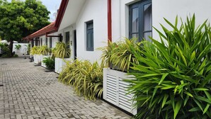 A white building with a red roof and a brick pathway leading to the entrance. - Neem Tree House (Trincomalee)