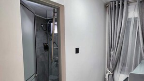 A small, modern bathroom with a glass shower enclosure, a toilet, and a sink.