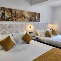 Habitación cuádruple Deluxe, vistas a la ciudad | Ropa de cama de alta calidad y edredones de plumas