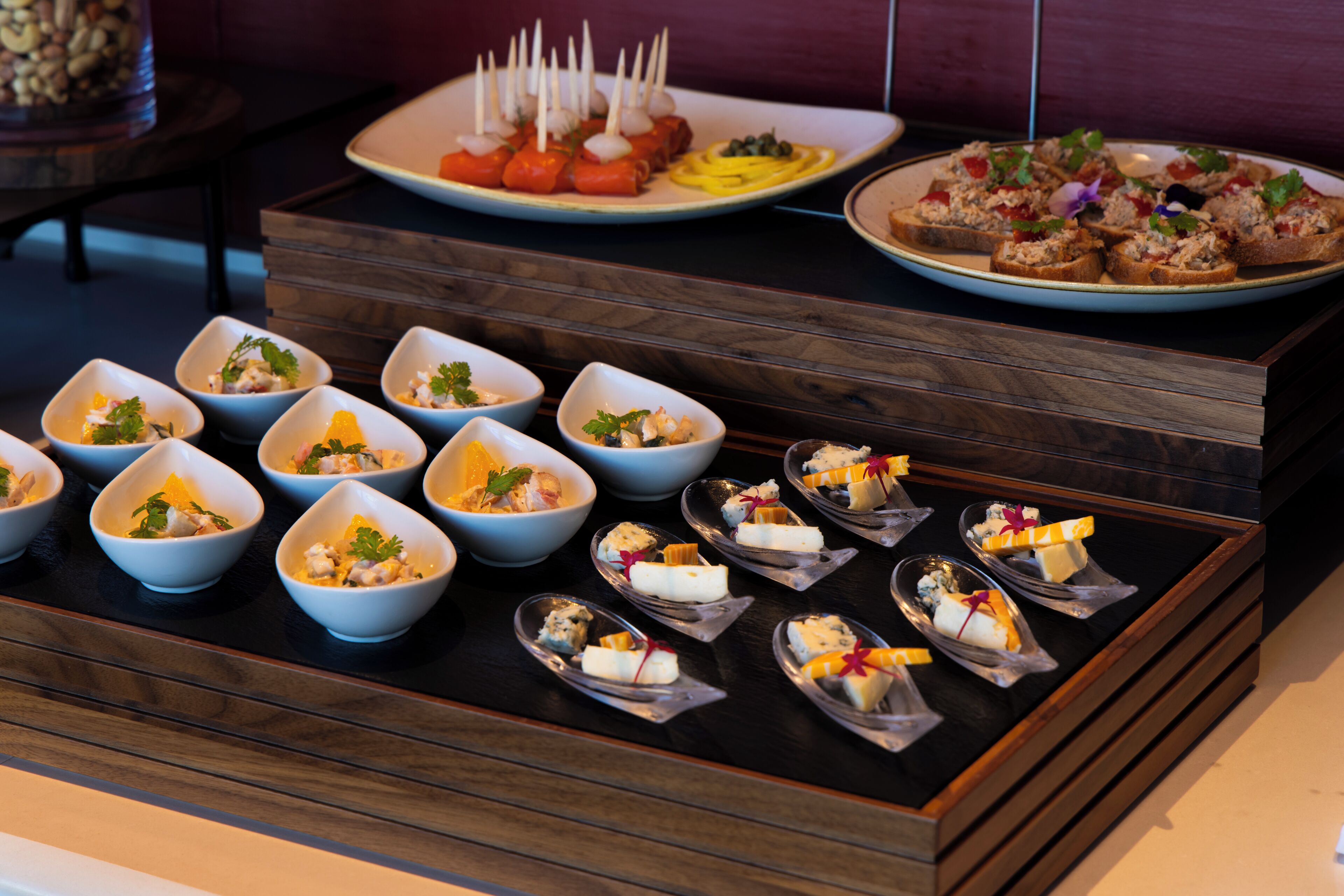 A variety of appetizers arranged on a wooden serving board.