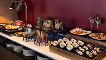 A buffet setup with various food items and containers.