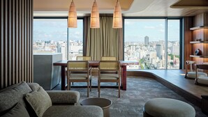 A modern hotel room with a dining area, a sofa, and a view of the city. - The Royal Park Hotel Iconic Naha (Naha)