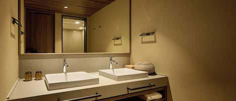 A modern bathroom with two sinks, a large mirror, and built-in storage.