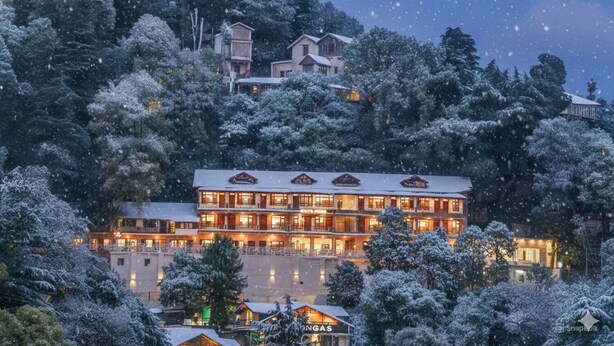 Een meerlaags hotel met een besneeerd landschap.