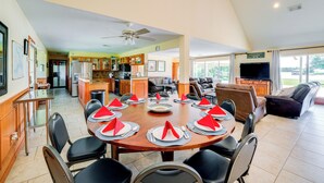 A spacious dining area with a round table set for a meal, surrounded by chairs. - Sunrise Cove RC LLC: Lakefront Home w/ 2 Casitas! (Kerens)