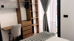 A bedroom with a bed, a desk, a chair, and a wardrobe.