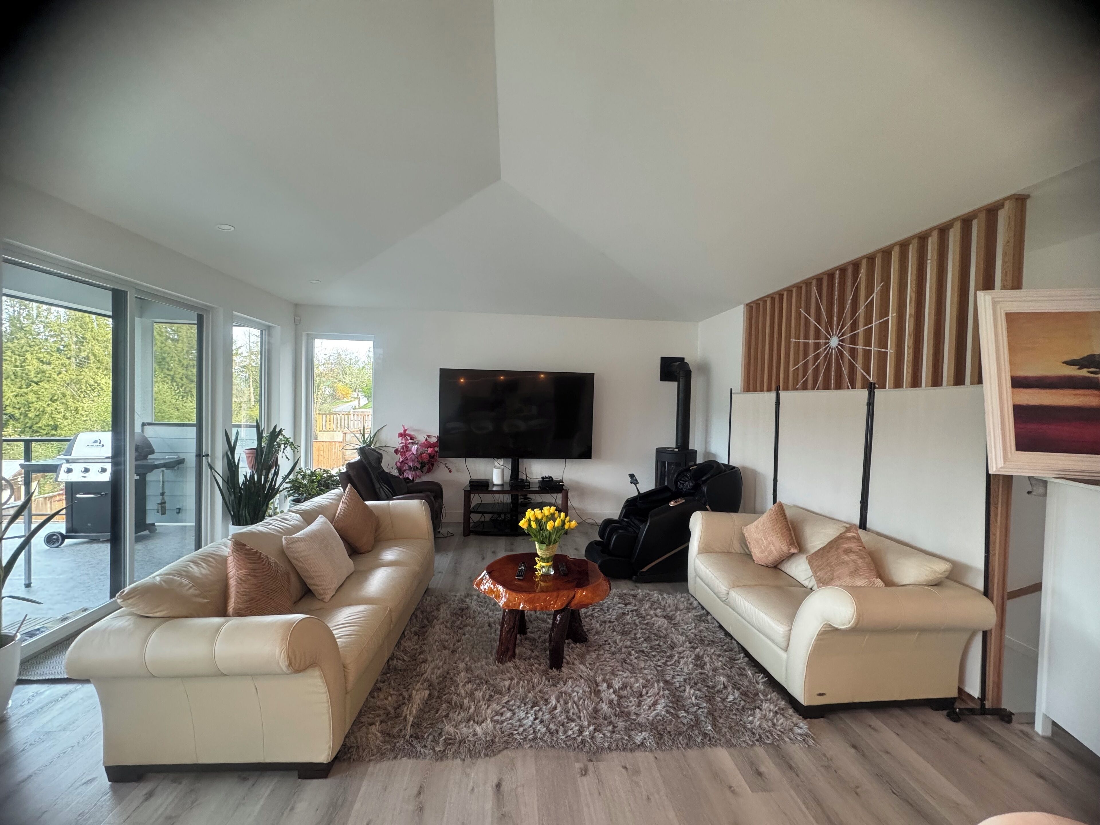 Un salon moderne avec deux canapés, un téléviseur et une cheminée.