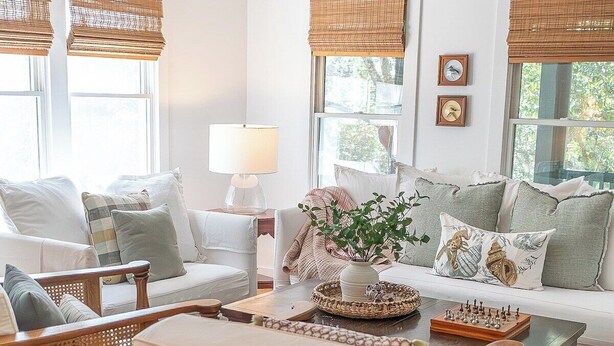 A living room with wicker furniture, a coffee table with chess, and a ceiling fan. - The Long Time PET FRIENDLY Cape Fear Station (bald head island)