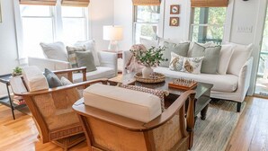A living room with a sofa, chairs, a coffee table, and a lamp. - The Long Time PET FRIENDLY Cape Fear Station (bald head island)