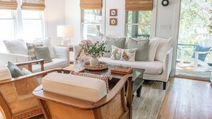 A cozy living room with a sofa, chairs, a coffee table, and a dining table. - The Long Time PET FRIENDLY Cape Fear Station (bald head island)