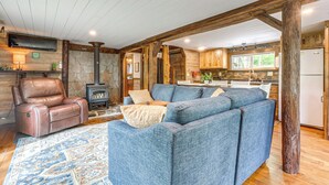 A cozy living room with a fireplace, a leather recliner, and a blue sofa.