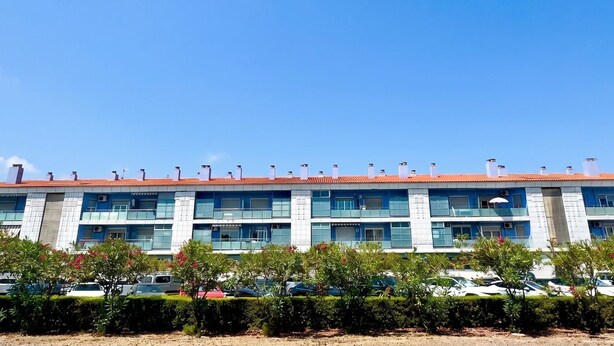 A multi-story building with a red-tiled roof, multiple balconies, and air conditioning units. - FIRST LINE BEACH PARTMENT (València)