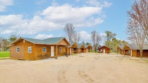 A row of wooden cabins with a gravel driveway.