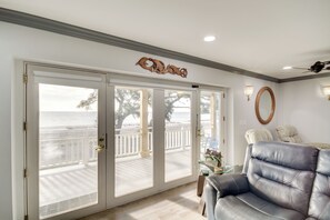 Relax on the balcony with a view of the water, featuring a comfortable sofa and sliding glass door.