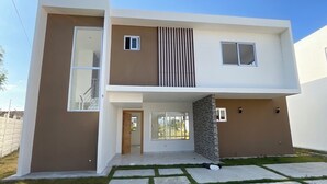 A modern two-story house with a flat roof, large windows, and a stone accent wall. - Comfort & Privacy:Family, Couple - rent Villa in Punta Cana with A/C, WIFI, POOL (Punta Cana)