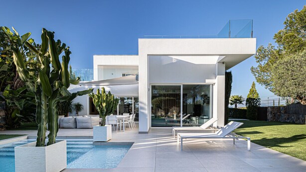 Una casa moderna con piscina, area relax esterna e un cactus.