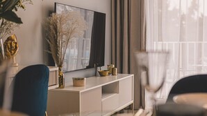 A modern living room with a white console table, a large mirror, and decorative items including a vase with dried flowers.
