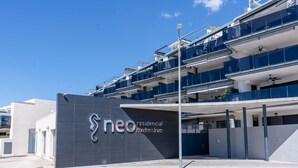 A modern building with a prominent logo and the name "neo residencial mediterráneo" on the facade.