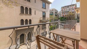 A balcony with a metal railing, a wooden table, and a bench. - Chic & Spacious 3BR Apartment at National Museum (Athina)