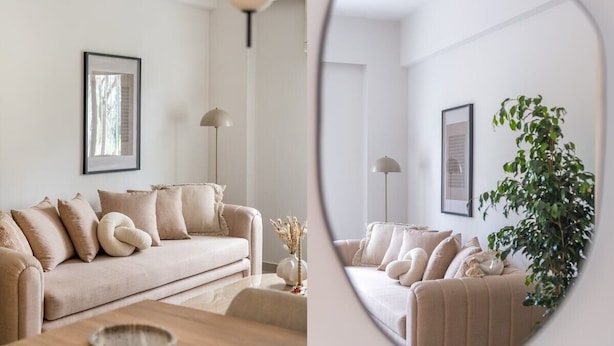 A modern living room with a beige sofa, a floor lamp, and a framed picture on the wall.