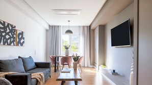 A modern living room with a sofa, coffee table, and dining area. - Monastiraki Living: Deluxe 2BR Apartment (Athens)