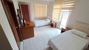 A hotel room with two beds, a desk, and a wardrobe. - YILMAZ OTEL (Akcakoca)