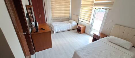 Una habitación de hotel con dos camas, un escritorio y un armario.