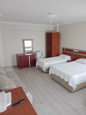 A hotel room with two beds, a desk, a wardrobe, and a mirror. - YILMAZ OTEL (Akcakoca)