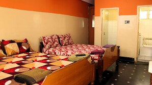 A room with a bed, a wooden wardrobe, and a bathroom door. - I-ROOMZ Surya Deluxe Lodge (Chikkaballapur)