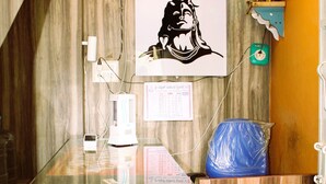 A reception desk with a wooden counter, a wall-mounted calendar, and a framed picture. - I-ROOMZ Surya Deluxe Lodge (Chikkaballapur)