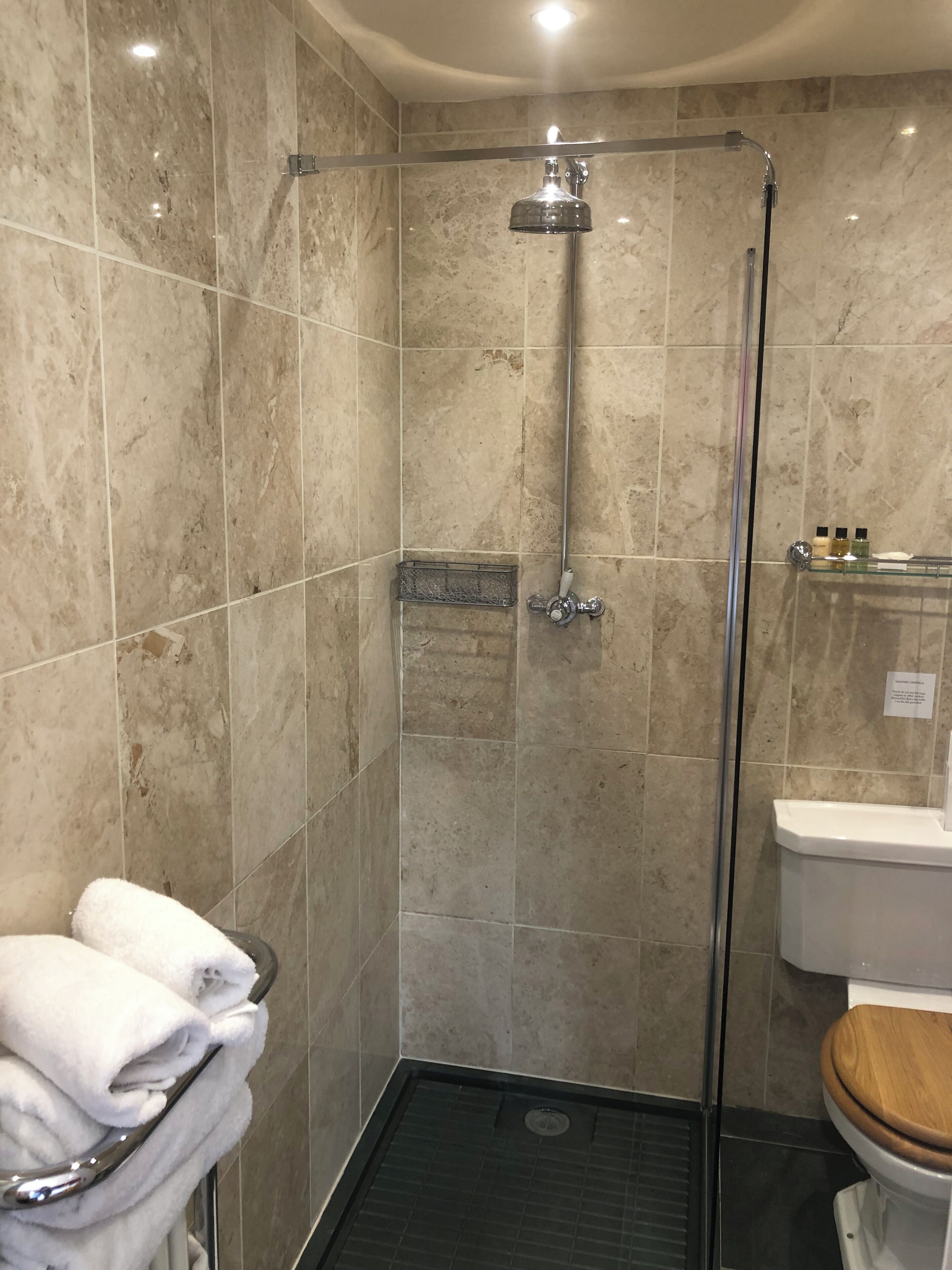 A bathroom with a shower, a toilet, and a sink.