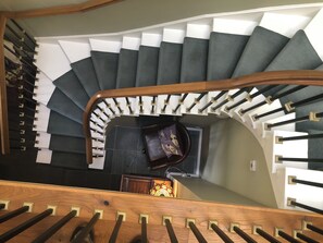 Eine Wendeltreppe mit Holzwertlauf und schwarz-weißen Stufen.