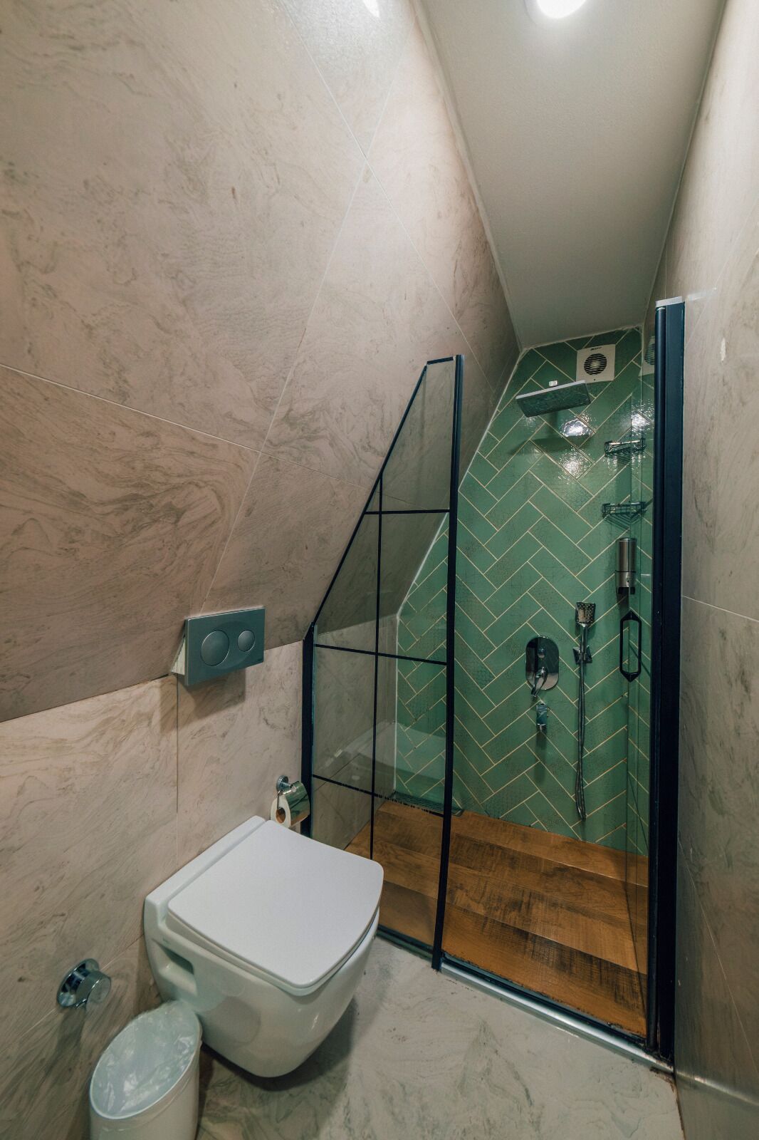 A modern bathroom with a glass-enclosed shower, a toilet, and a sink.