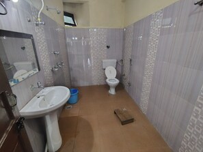 Casa de banho com lavatório, sanita e chuveiro.