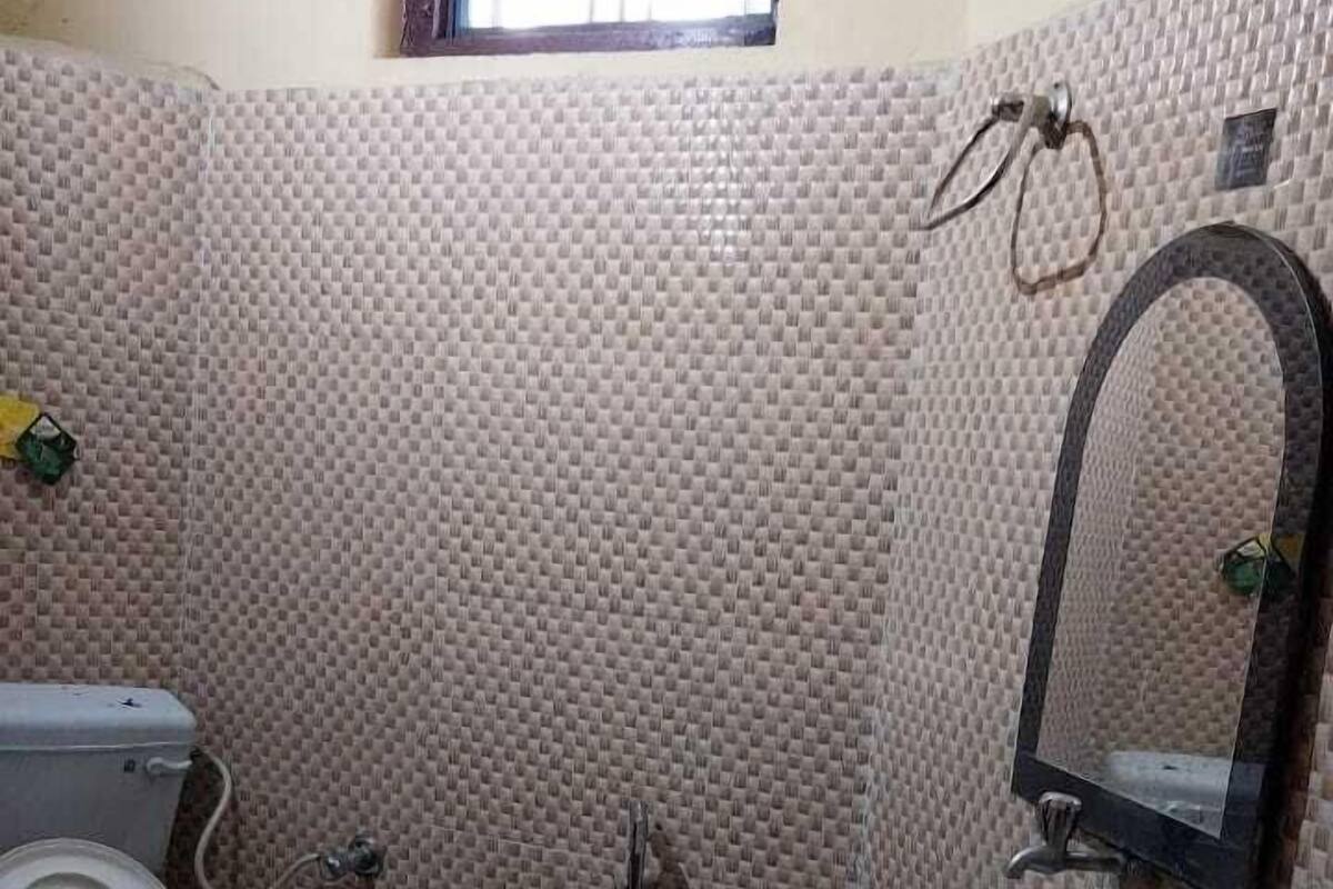 Une salle de bain avec des toilettes, un lavabo et une fenêtre.