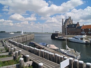 Moored boats line the waterfront piers, with a historic building visible in the background.