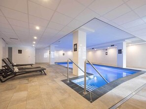 Relax by the pool in a serene atmosphere, surrounded by lounge chairs and a clean, minimalist design.