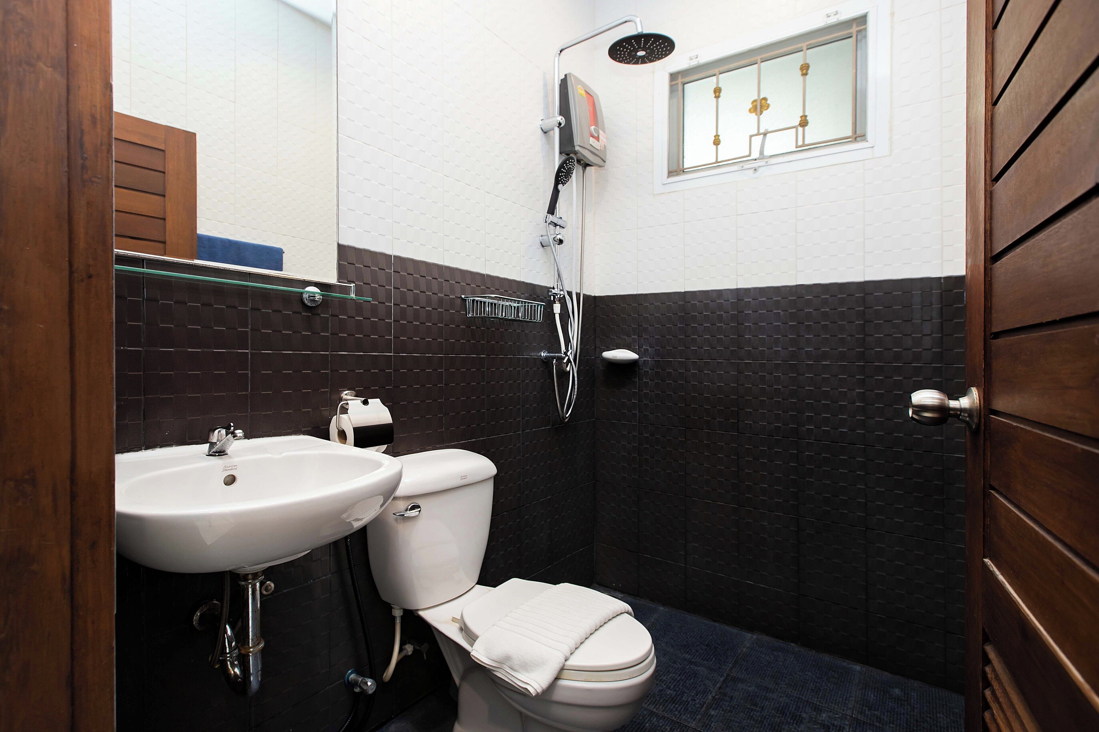 A bathroom with a white sink, toilet, and shower.