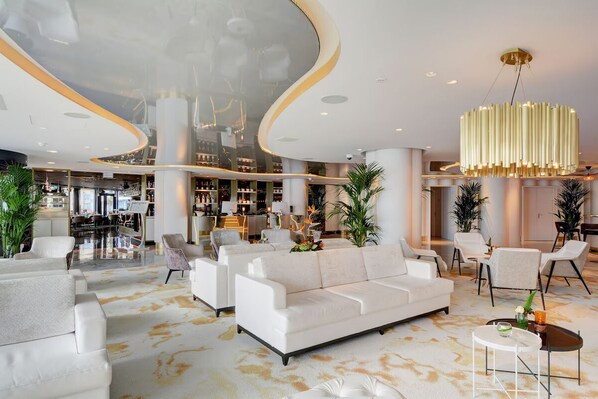 Relax in our spacious lobby with a central seating area, featuring a sofa, armchairs, and a round coffee table.