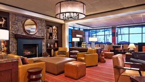 A spacious lobby with a fireplace, comfortable seating, and large windows offering views.