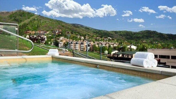 A swimming pool with a view of a hillside town.
