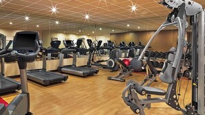 A gym with treadmills, elliptical machines, and weightlifting equipment.
