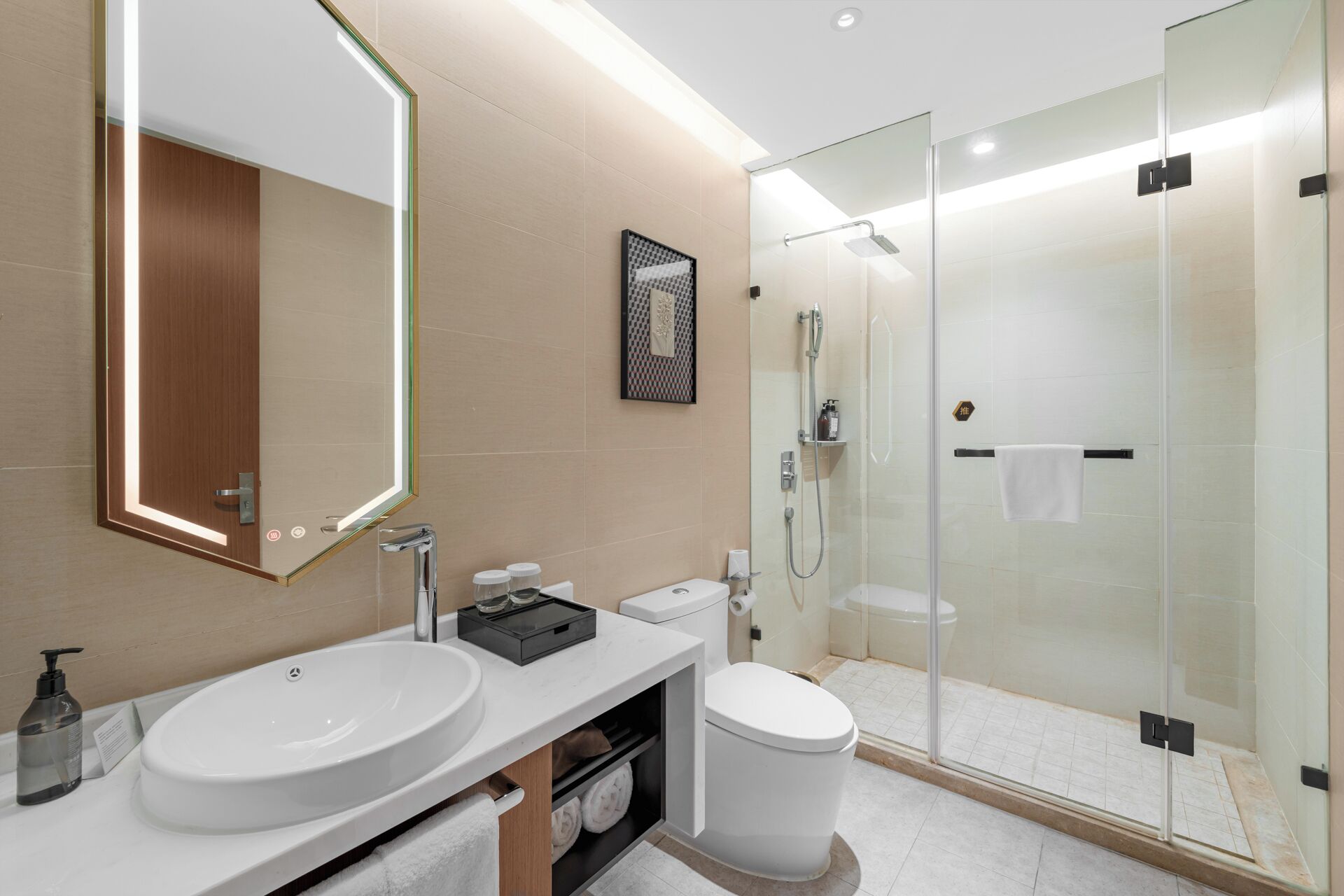 A modern bathroom with a large mirror, two sinks, a toilet, and a glass-enclosed shower area.