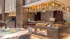 Un restaurant moderne doté d’un comptoir en marbre, d’un bar et d’un espace salon avec une table en verre.