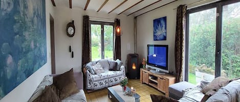 A cozy living room with a sofa, a television, and a fireplace.