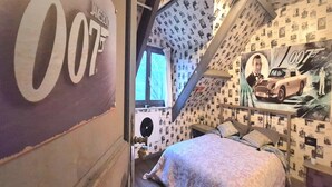 Een slaapkamer met een grote poster van een auto en het nummer '007' aan de muur.
