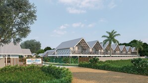 Ein Resort mit mehreren bungalowartigen Gebäuden, einem gepflegten Garten und blauem Himmel.